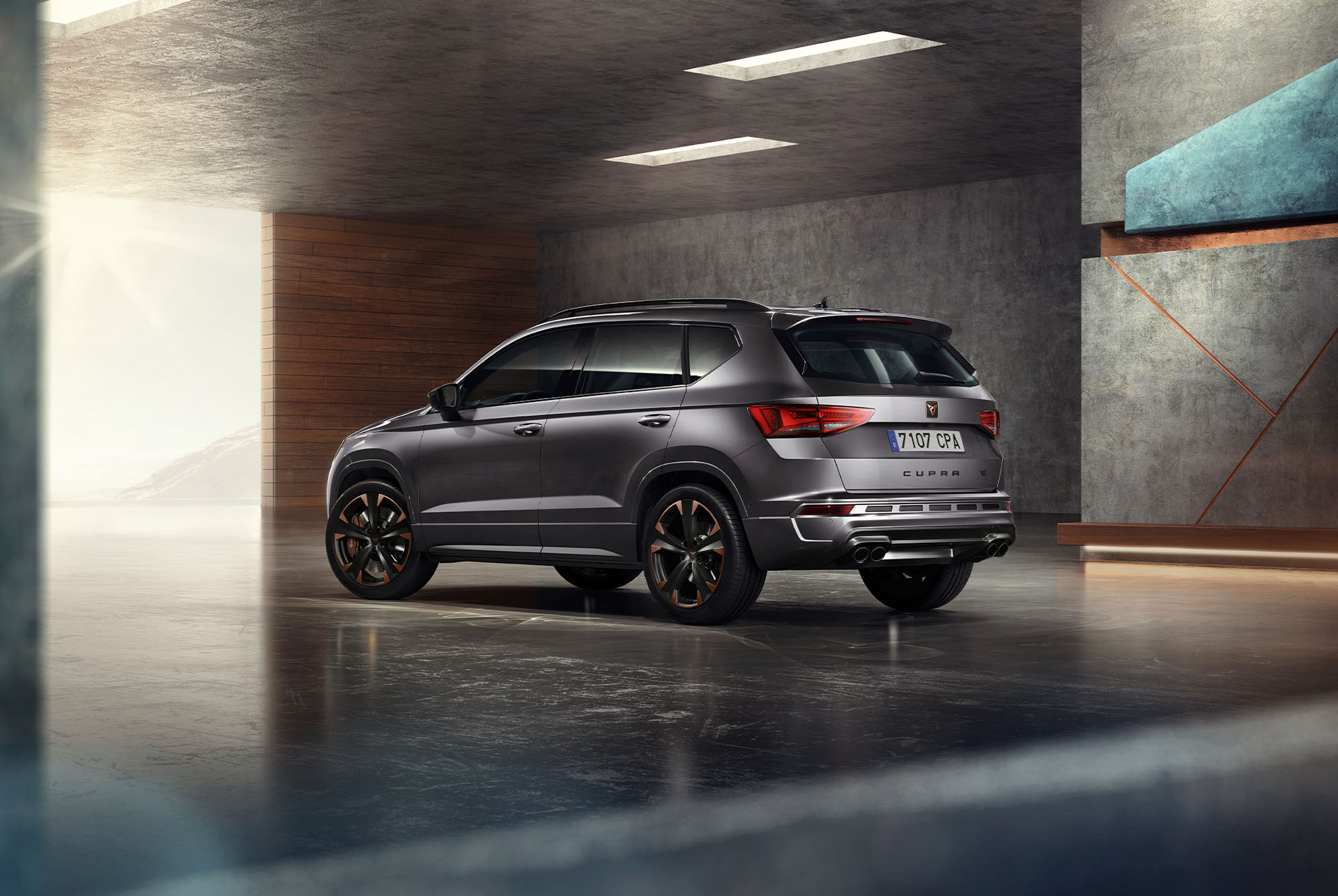 Un suv cupra ateca grigio su sfondo bianco. La vettura presenta un'accattivante griglia anteriore, gruppi ottici a led e cerchi in lega color rame, che ne mettono in evidenza il design sportivo.