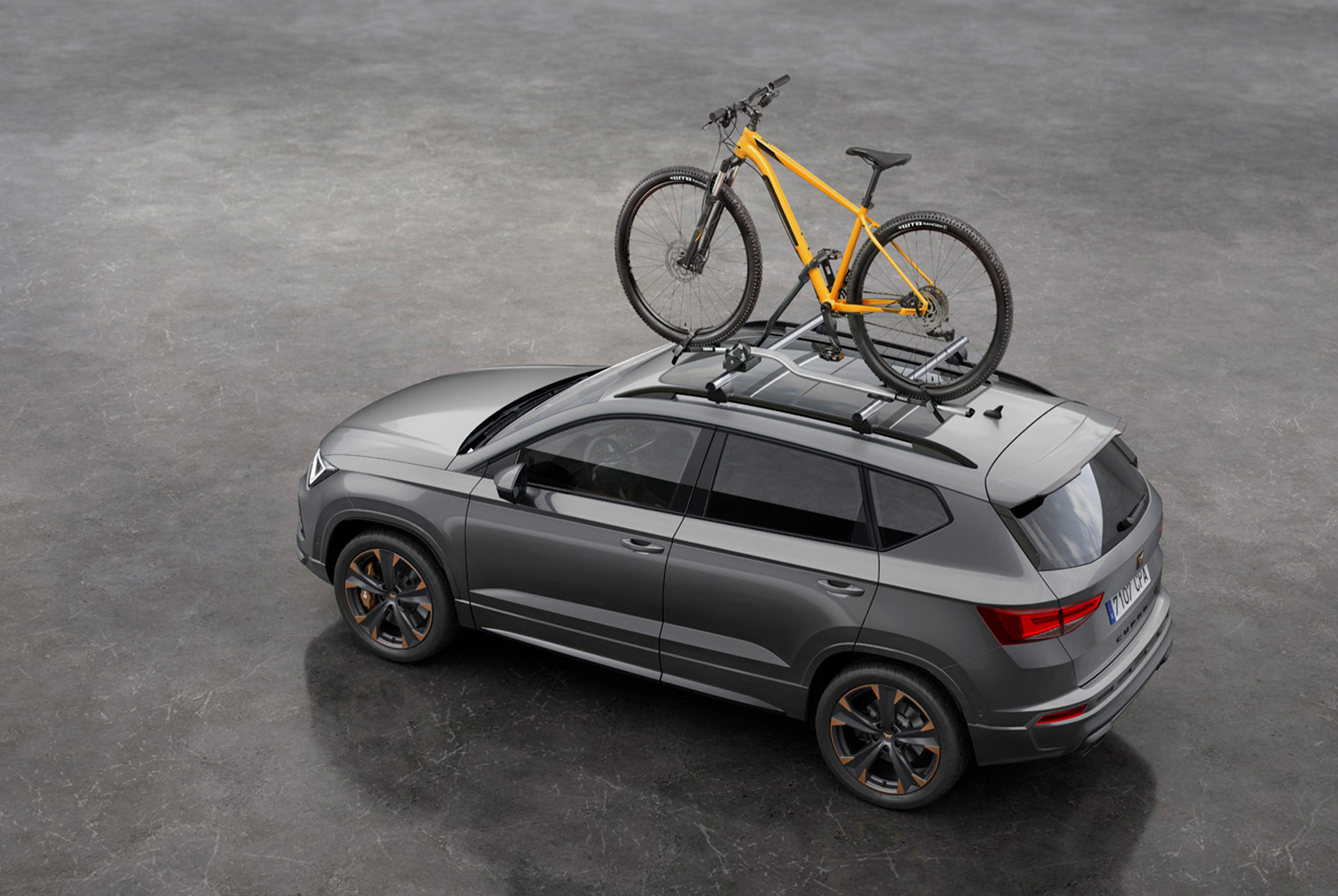 CUPRA Ateca equipaggiata con un portabici da tetto appositamente creato, pronta per un viaggio avventuroso. 