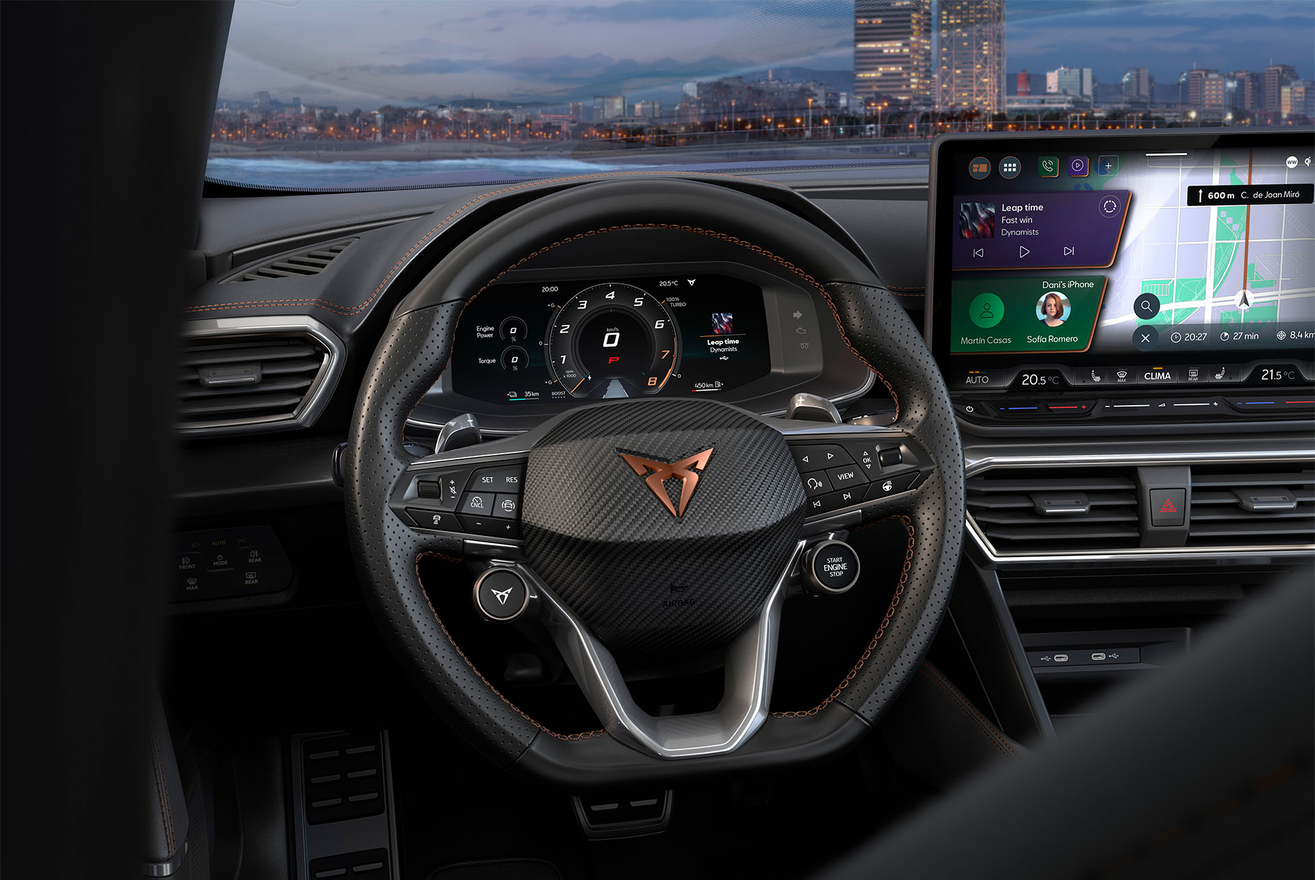 Volante CUPRA con logo, cuciture color rame, pulsanti satellitari e riscaldamento integrato. Skyline di Barcellona e monitor del sistema di infotainment.