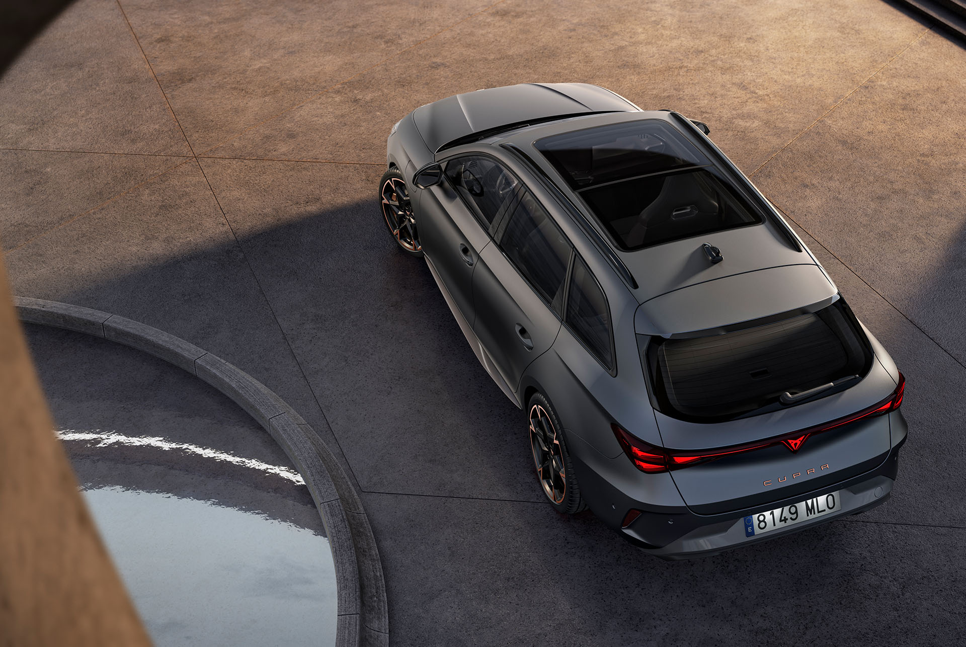 Tecnologia nuova CUPRA Leon Sportstourer 2024 Hybrid, parcheggiata su cemento, vista dall’alto del tetto panoramico e del portellone posteriore elettrico